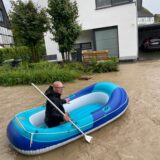 Ein Anwohner der Dorfstraße in Billmerich paddelt in einem Schlauchboot durch die Wassermassen.