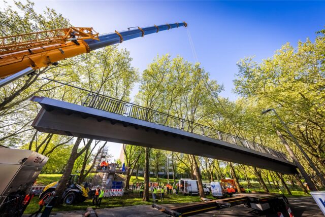 Die grunderneuerte Fußgänger- und Radwegbrücke wird an der gesperrten B1 wieder montiert.