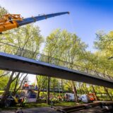 Die grunderneuerte Fußgänger- und Radwegbrücke wird an der gesperrten B1 wieder montiert.