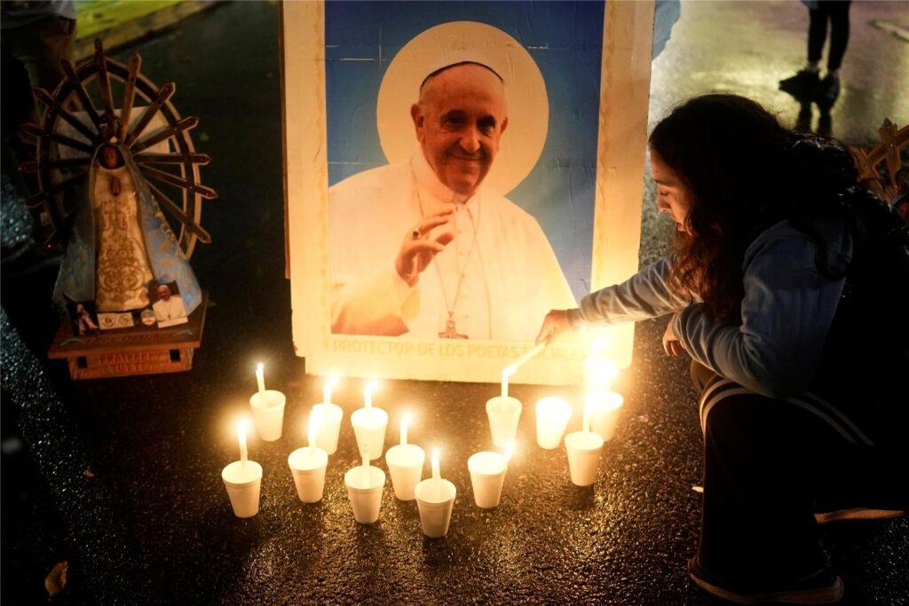 Ein Trauernder zündet eine Kerze vor einem Bild des verstorbenen Papstes Franziskus vor der Kathedrale in Buenos Aires an, während sein Begräbnis in Rom stattfindet.