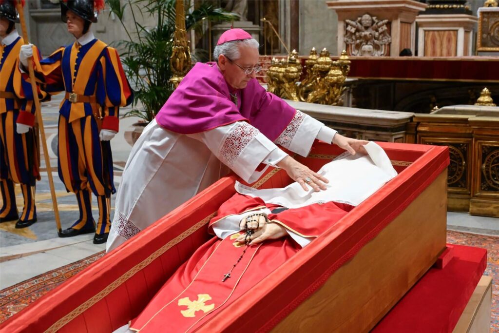 Erzbischof Diego Giovanni Ravelli legt ein Tuch auf das Gesicht von Papst Franziskus.