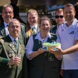 Die Schützen in Tracht. Freibad-Geschäftsführer Dirk Weise (r.) nimmt eine Torte entgegen. Hier sind alle zusammen inklusive auf dem Foto zu sehen.