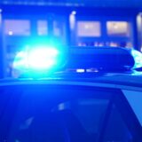 Ein Streifenwagen der Polizei steht mit eingeschaltetem Blaulicht an einem Einsatzort.