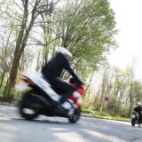 Zwei Motorradfahrer fahren über eine Landstraße.