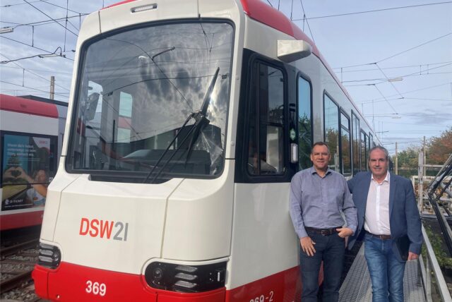 Thomas Steinröder und Ralf Habbes von DSW21 stehen neben einer von der Firma HeiterBlick neugebauten Stadtbahn auf dem Betriebshof in Dorstfeld.