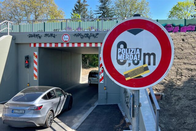 Vor der Unterführung unter der Eisenbahnlinie an der Mühlenstraße in Unna weist ein Schild die maximale Durchfahrthöhe aus. Allerdings ist es nicht mehr lesbar, weil Unbekannte zwei Aufkleber darauf geklebt haben.
