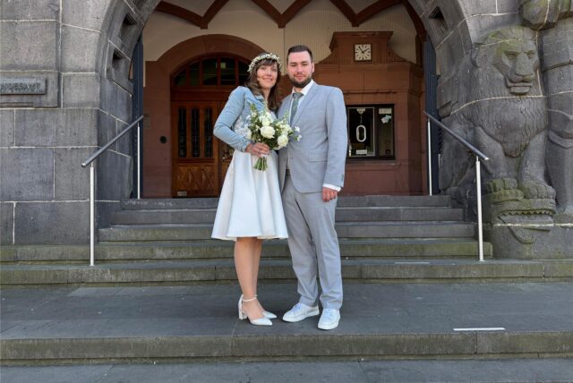 Zwei Menschen stehen vor dem Rathaus in Recklinghausen kurz vor der Hochzeit.