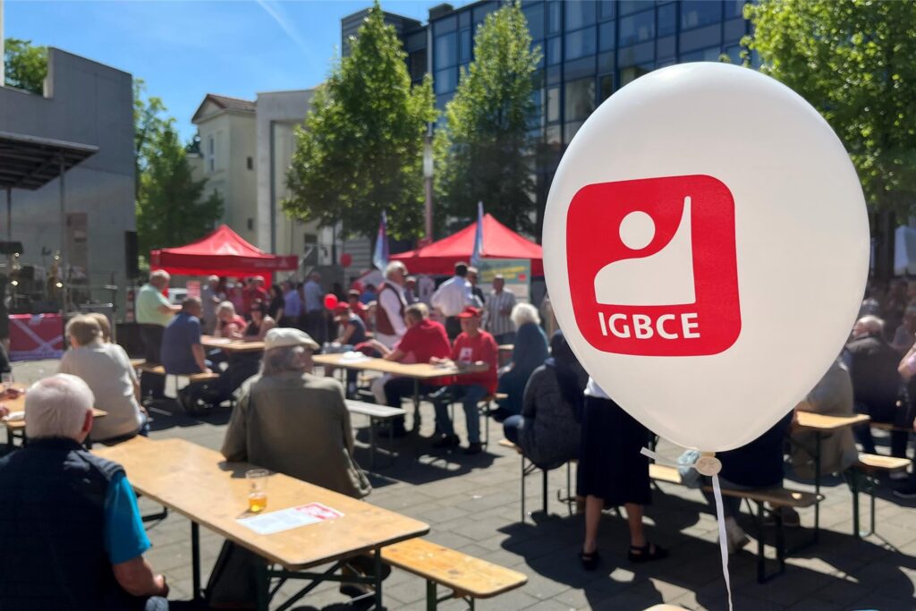 Auf dem Platz der Kulturen in Unna sitzen Gäste der Maikundgebung an Biertischen. Ein Luftballon von der IGBCE schwebt im Vordergrund. Auf dem Platz der Kulturen in Unna sitzen Gäste der Maikundgebung an Biertischen. Ein Luftballon von der IGBCE schwebt im Vordergrund.