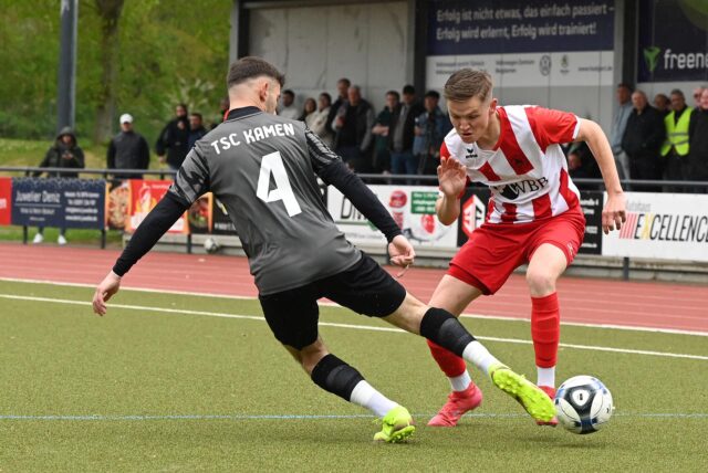 Zwei Fußballer spielen den Ball.