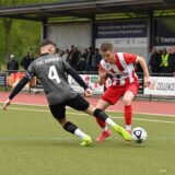 Zwei Fußballer spielen den Ball.