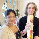 Die Christen Mia und Benjamin halten in der alt-katholischen Kirche in Kley eine Kerze in der Hand.