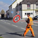 Ein Mitarbeiter von Straßen NRW trägt ein Tempo-30-Schild über die Kleistraße in Unna.