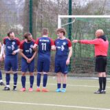 Fußballspieler stehen bereit zum Freistoß und bauen dafür eine Mauer indem sie sich festhalten.
