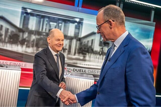 Bundeskanzler Olaf Scholz (l, SPD) steht neben Friedrich Merz