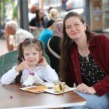 Frau und Kind essen Waffel und Kuchen