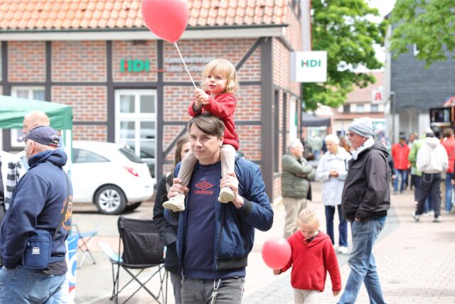 Vater mit Kind auf der Schulter und weitere Besucher.