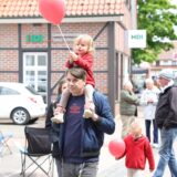 Vater mit Kind auf der Schulter und weitere Besucher.