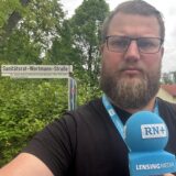 Ein Reporter aus Lünen steht vor dem Schild der Sanitätsrat-Wortmann-Straße.