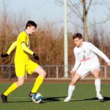 Zwei Fußballer spielen den Ball.