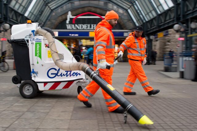 Am Hamburger Hauptbahnhof reinigen zwei Männer den Boden mit einem Sauggerät.