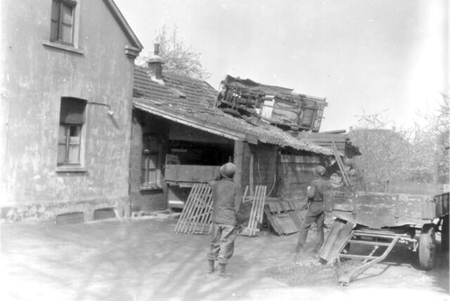Das Foto soll am 11. April 1945 in Unna entstanden sein und ist in einem Archiv der 8. US-Panzerdivision so beschriftet: „Zwei Soldaten der 9. US-Armee fragen sich in der kürzlich eroberten Stadt Unna, wie dieses deutsche Fahrzeug auf das Schuppendach gelangte. Unna liegt im Ruhrgebiet und die 8. Panzerdivision stieß auf hartnäckigen Widerstand einer großen Zahl von SS-Truppen, die die Stadt verteidigten.“
