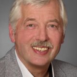 Bernhard Albers, Ortsvorsteher von Unna-Billmerich, neben einem Haufen aus Grünschnitt und Gartenabfällen.