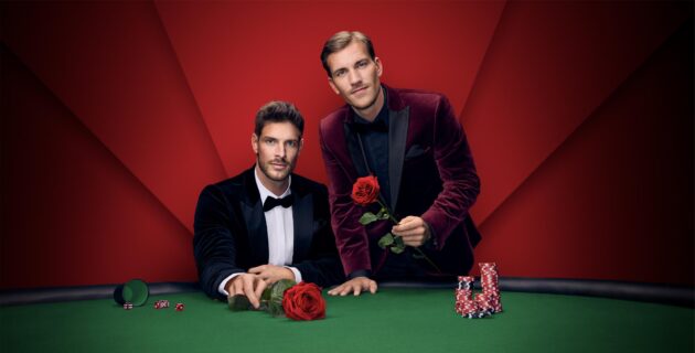 Martin Braun (links) und Felix Stein (rechts) – die beiden Single-Männer in der neuen Staffel „Die Bachelors“ – hinter einem Poker-Tisch mit Poker-Chips und Rosen