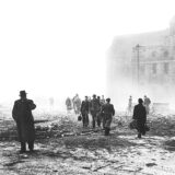 Menschen gehen durch Trümmer und Rauch auf dem Hansaplatz nach einem Bombenangriff.