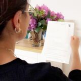 Eine Frau hält einen Brief der Staatsanwaltschaft Dortmund in den Händen.