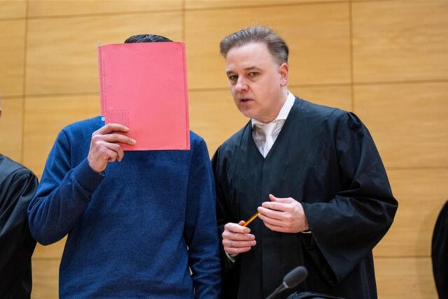 Der Angeklagte (l) steht mit seinem Anwalt Burkhard Benecken zu Beginn des Prozesses (Dezember 2024) um einen gewaltsam ums Leben gekommenen 20-Jährigen in einem Saal des Landgerichts.