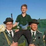 Jona Borgmann wird als neuer Kinderschützenkönig des Schützenvereins Bentrop von zwei Schützen auf Schultern getragen.