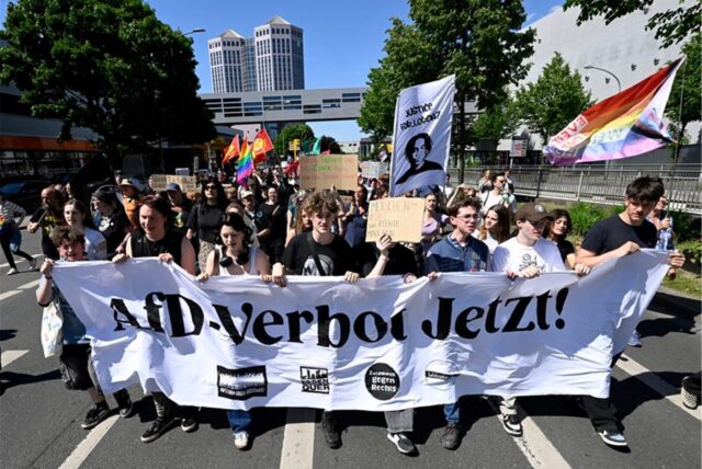 Menschen demonstrieren beim bundesweiten Aktionstag «Keine Ausreden mehr – AfD-Verbot jetzt!» und ziehen mit einem Banner mit der Aufschrift „AfD-Verbot Jetzt!“ durch die Stadt.