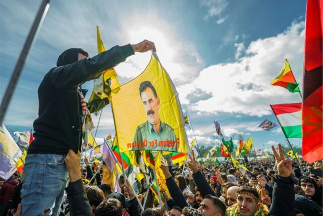 Menschen nehmen im März an der zentralen Feier in Frankfurt zum kurdischen Neujahrsfest «Newroz»  teil und schwenken dabei Fahnen