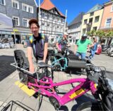 Auf dem Bild ist ein Mann zu sehen, der neben einem E-Lastenrad steht.