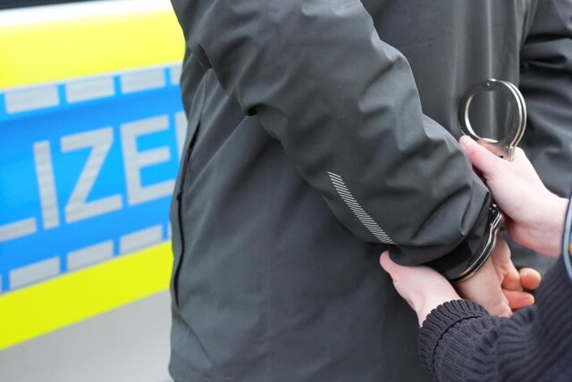 Einem Mann werden Handschellen angelegt.