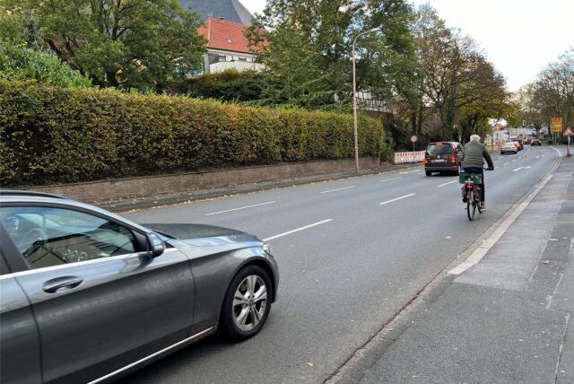 Ein Radfahrer fährt auf der rechten Spur des Ostrings, mit einem Auto kurz hinter ihm.