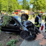 Feuerwehrleute neben dem verunglückten Kleinwagen.