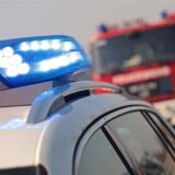Ein Polizei- und ein Feuerwehrwagen stehen an einer Straße.