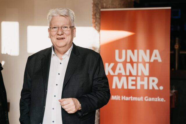 Hartmut Ganzke vor seinem Wahlplakat mit dem Motto „Unna kann mehr“