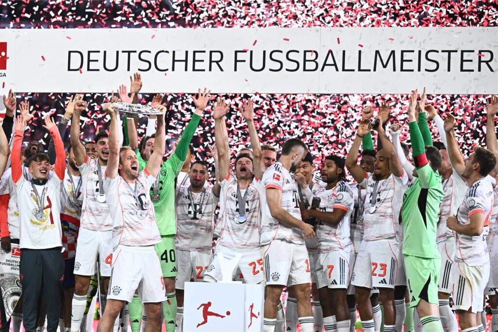Die Spieler des FC Bayern München jubeln mit der Meisterschale, die Harry Kane in den Händen hält. Die Spieler des FC Bayern München jubeln mit der Meisterschale, die Harry Kane in den Händen hält.