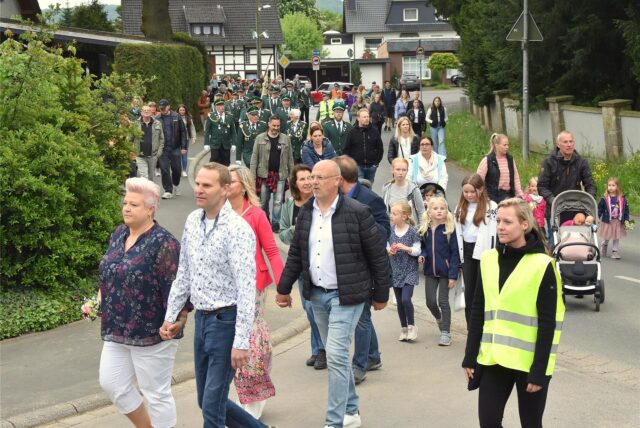 Ein Schützenumzug läuft über eine Straße.