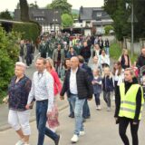 Ein Schützenumzug läuft über eine Straße.