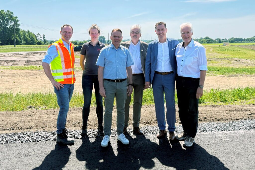 Eine Gruppe von Menschen vor dem Neubaugebiet. Eine Gruppe von Menschen vor dem Neubaugebiet.