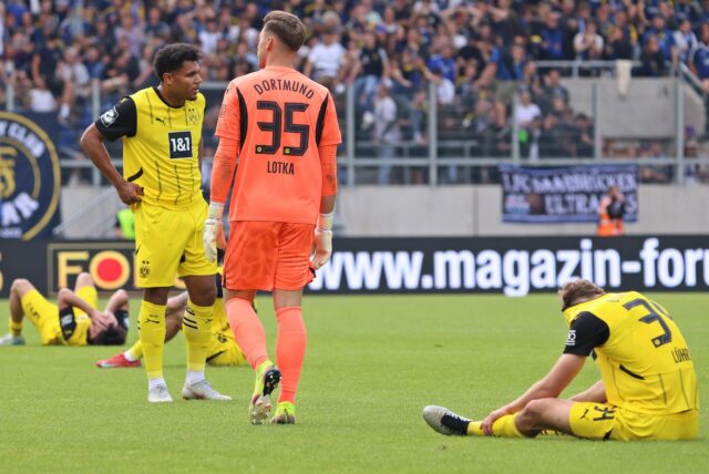 Yannik Lührs sitzt auf dem Rasen und steckt seinen Kopf in sein Trikot.