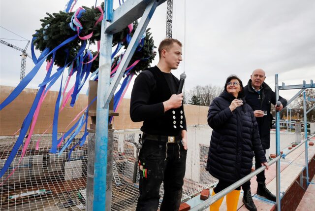 Mehrere Personen stehen auf dem Dach des Sesekebads in Kamen neben einem Richtkranz.