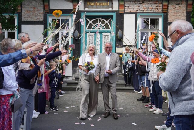 Mit einem Spielkartenregen empfingen die Doppelkopf-Gruppen von Susanne und Klaus das Brautpaar nach ihrer Hochzeit im Standesamt.