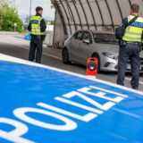 Polizisten kontrollieren an der Grenze ein Auto.