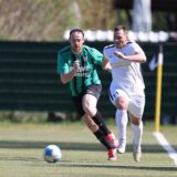 Zwei Fußballer laufen dem Ball hinterher.