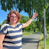Kirsten Braß aus Lünern steht an der Kuhstraße an einem Schildermast, an dem kein Schild angebracht ist. Eigentlich sollte dort eine Tafel Tempo 50 vermelden.