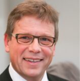 Ein Porträt von Baudezernent Arnulf Rybicki und ein Bild von der Bauselle mit Kanalbauarbeiten an der Brackeler Straße – dort, wo die Hoeschallee beginnen soll.